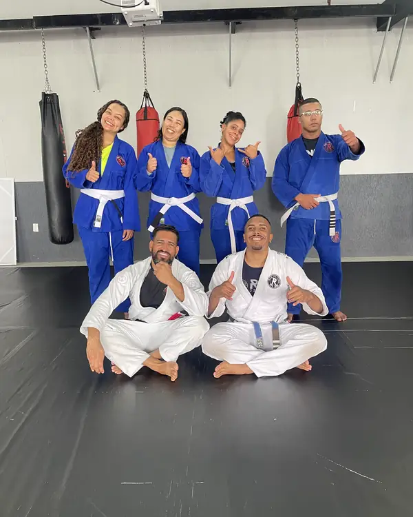 Alunas de kimono azul e alunos de kimono branco no tatame